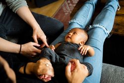 Cute new born baby lying down on mother’s lap
