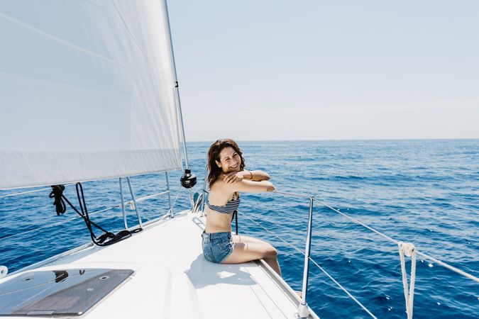 Woman in swimsuit sitting on boat