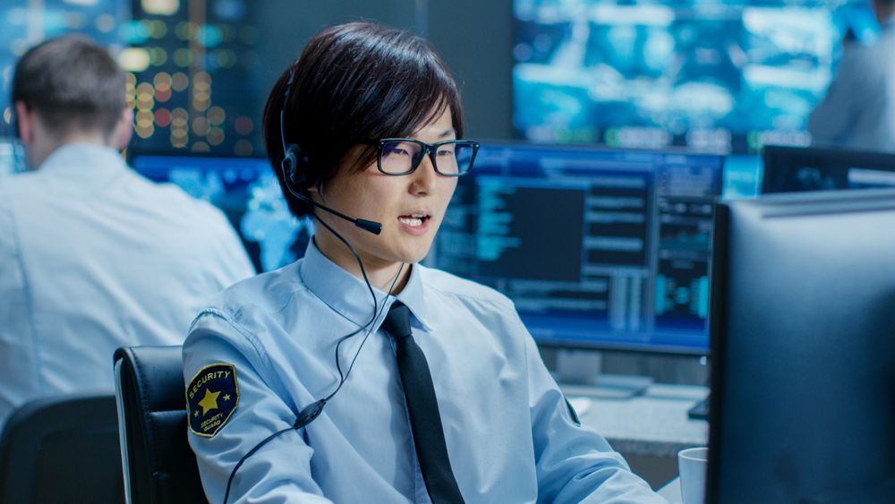 In the Security Command Center Officer at His Workstation Monitors Screens and Communicates with Patrols through Headset.