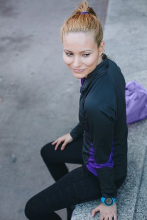 Woman in sportswear sitting outside