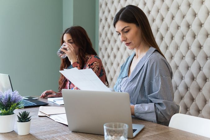 Focused women working on laptops in coworking space