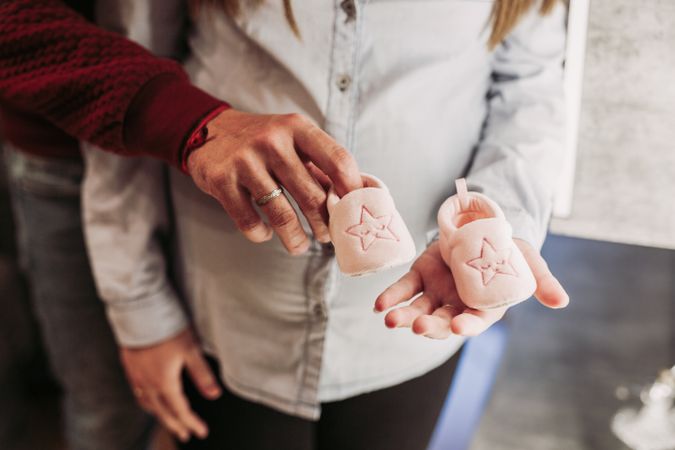 Couple expecting baby holding baby booties