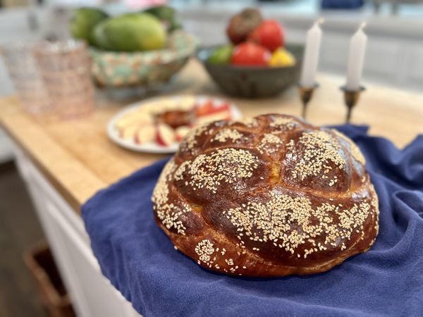 Challah, apples, honey, and candles for festive Rosh Hashanah holiday family meal