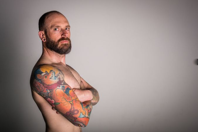 Young bearded guy with tattoos on hand