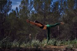 Faceless woman doing Warrior III asana in nature