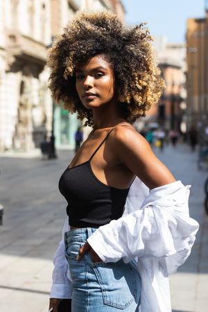 Black woman standing on street looking at camera
