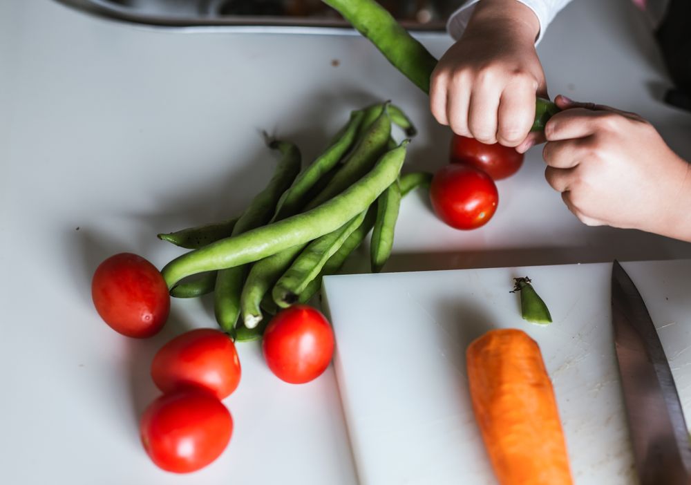 Anonymous boy preparing vegetables for salad