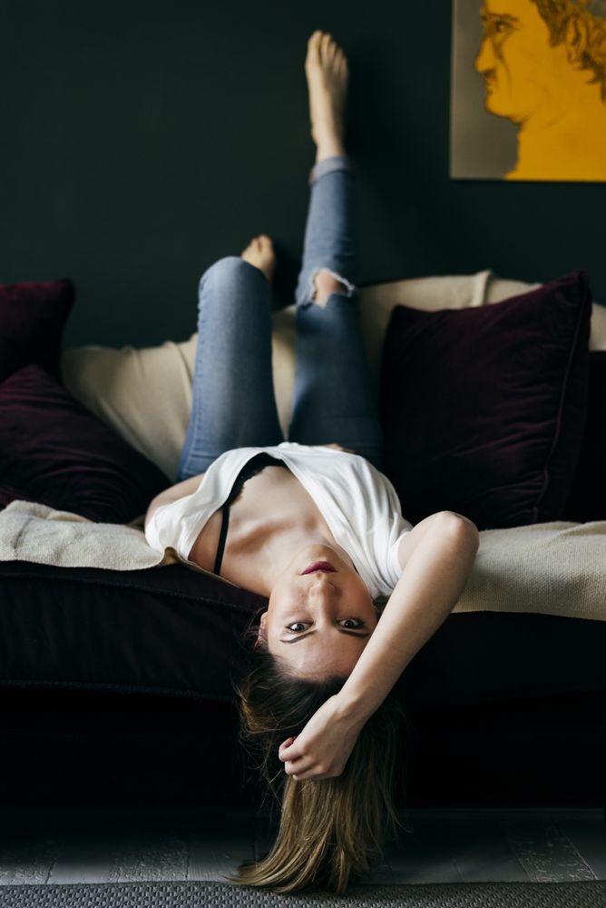 Cheerful female lying on sofa