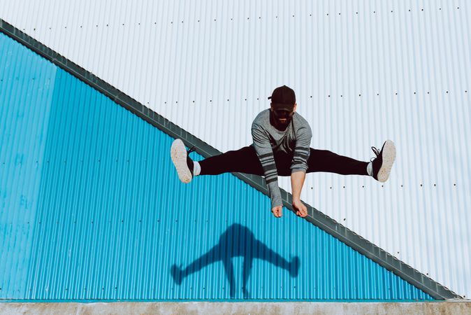 Trendy male flipping and jumping on street