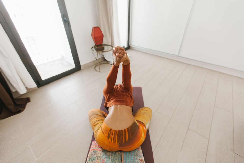 Anonymous sportive woman on the floor in yoga pose