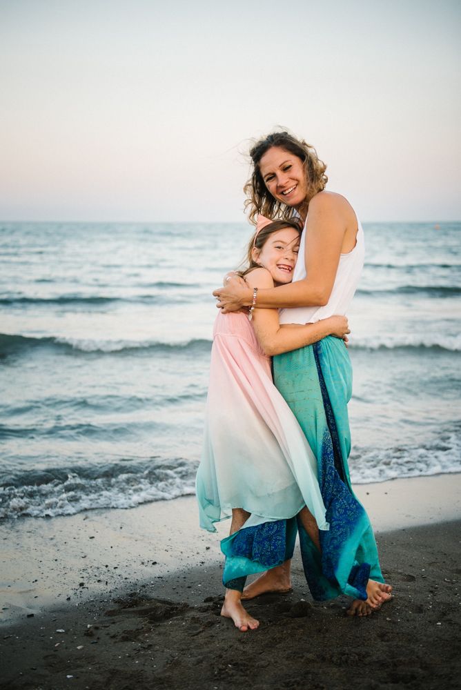 Beautiful mother and daughter embracing on beach