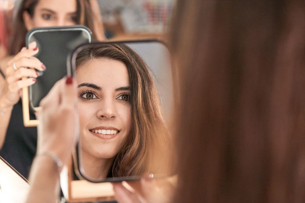 Content model looking at mirror in salon