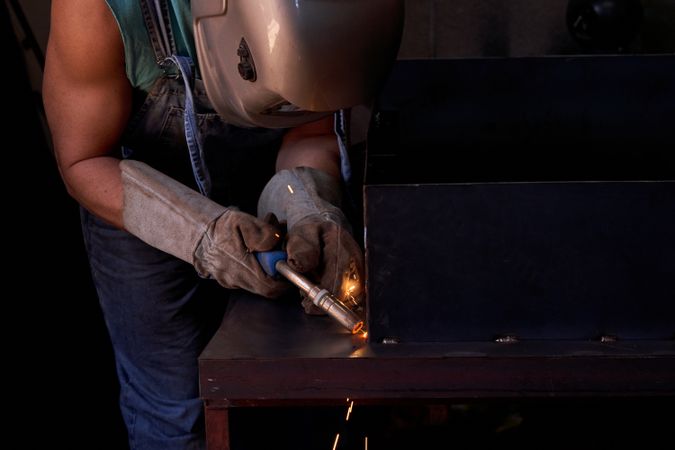 Anonymous man welding metal structure