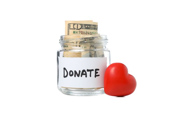 Heart and donate glass jar with money isolated on plain background