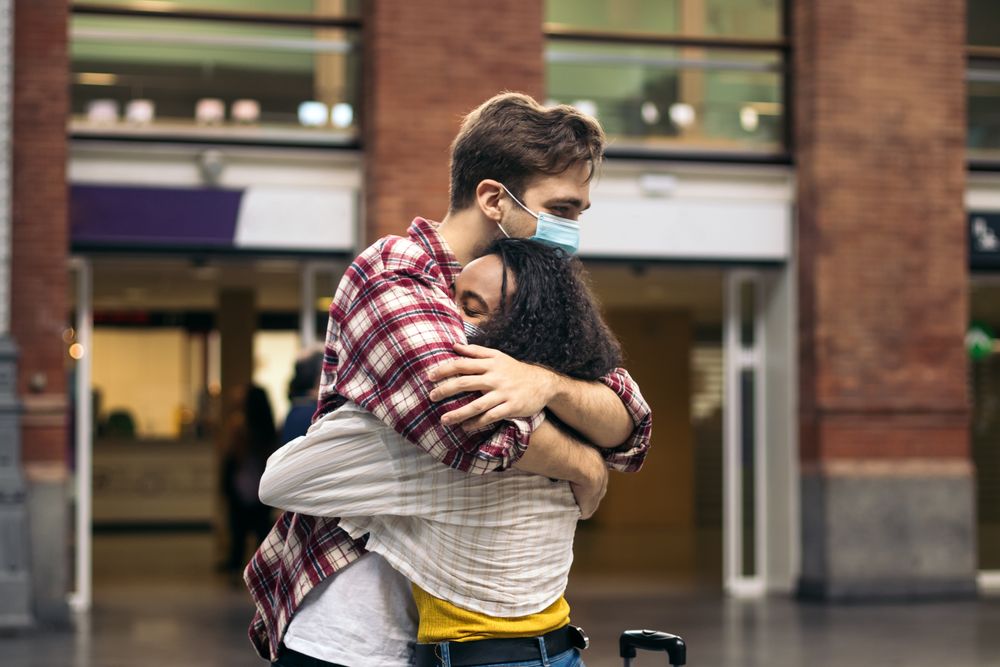 Young couple hugging at the station after a trip