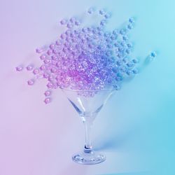 Martini glass with spilled pink glitter in vibrant bold gradient holographic colors