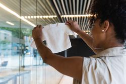 Pregnant Black woman with baby clothes near glass building