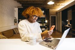 Young man using phone at home.
