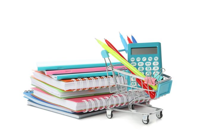 Shopping cart with pile of notebooks and calculator