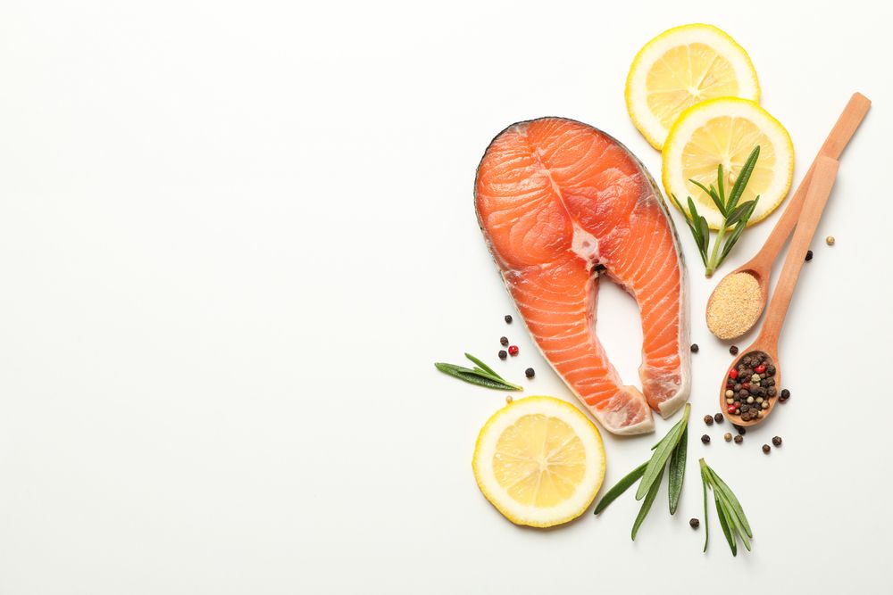Composition with salmon meat and spices on light background, top view