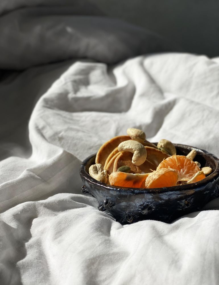 Health breakfast bowl on bedsheets in morning light