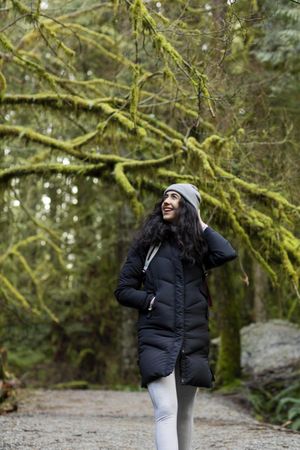 Happy young female walking on a  forest trail