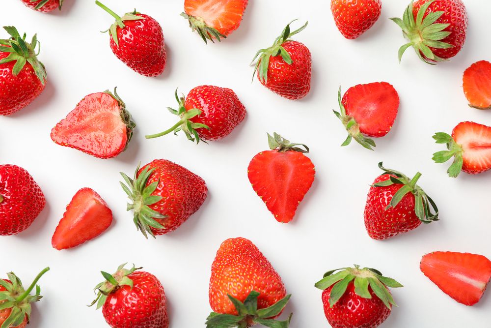 Flat lay composition with strawberries on light background, closeup. Summer sweet fruits and berries