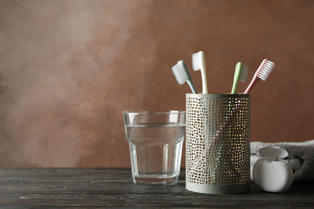 Tools for dental care on brown background, space for text