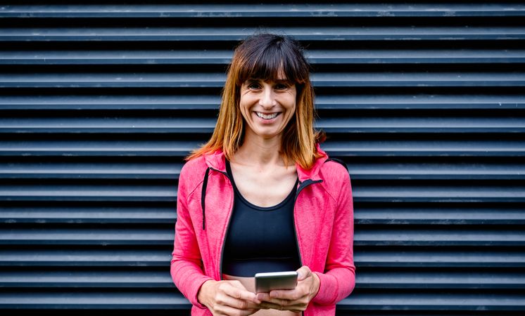 Happy female athlete with mobile phone