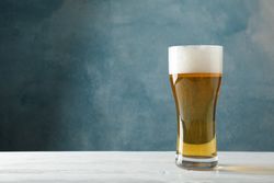 Mug with beer on wooden table, space for text