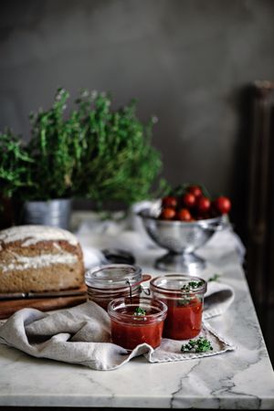 Fresh bread on napkin near tomatoes jam