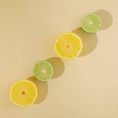 Fresh summer fruit with lemon and lime on sandy background