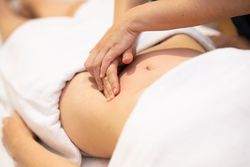 Physiotherapist working on patient’s stomach