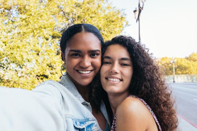 Cheerful women taking selfies outdoors
