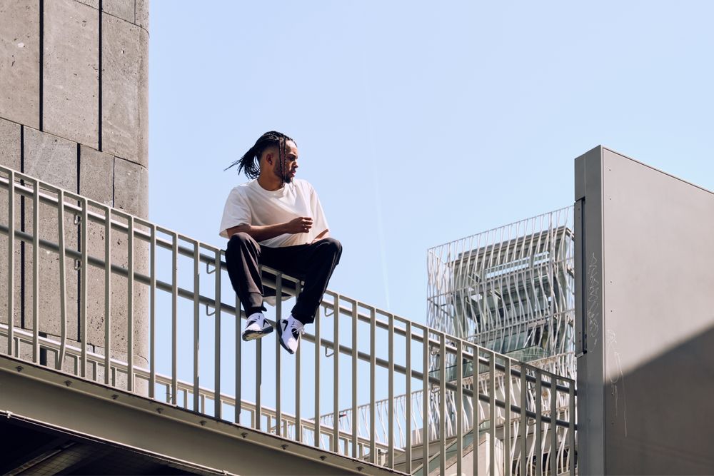 Black male sitting on bridge