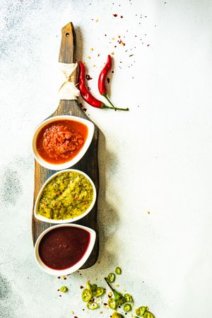 Top view of three flavorful spicy traditional Georgian sauces on grey counter