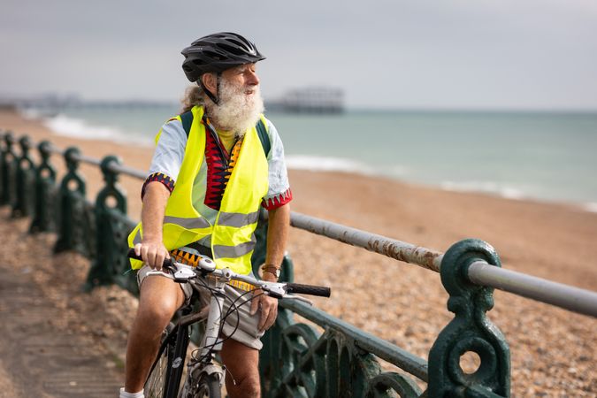 Content older man enjoying coastal view from bike