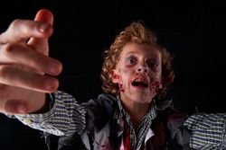 Boy disguised as zombie with blood and glitter with expression of fear