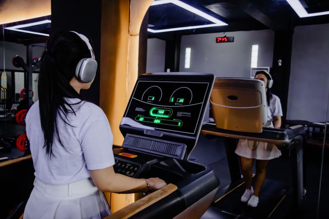 Two young women exercising on treadmills in a modern fitness centre