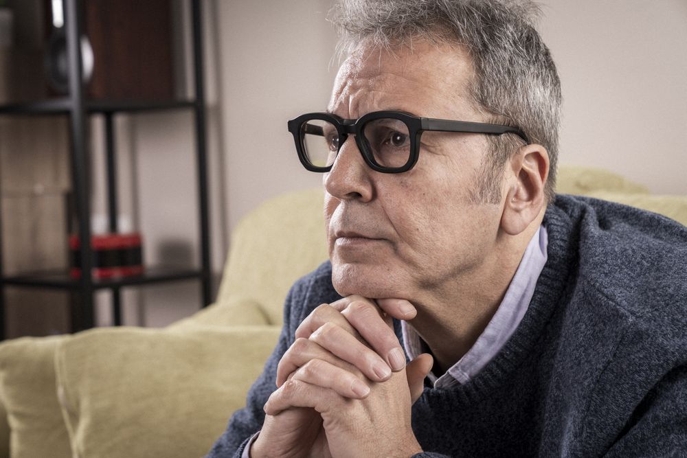 Serious mature man in deep contemplation at home.