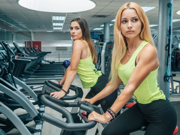 Young women exercising on machines together
