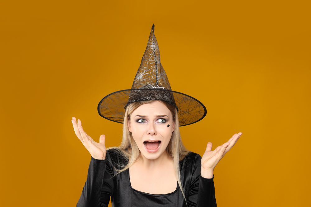 Concept of Halloween, young woman on yellow background