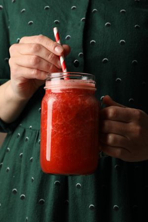 Woman hold glass jar of strawberry cocktail, close up. Summer drink