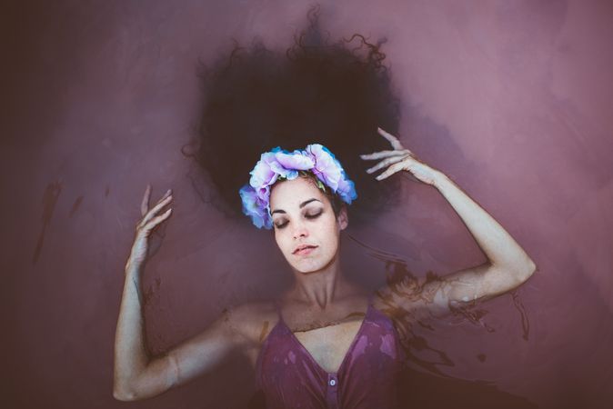 Woman with wreath lying in water