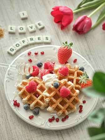 Delicious waffles with berries near inscription