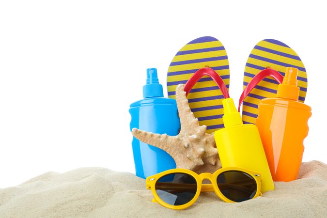 Summer vacation accessories in clear sea sand isolated on blank background. Summer vacation