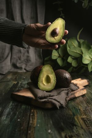 Person hands holding avocados
