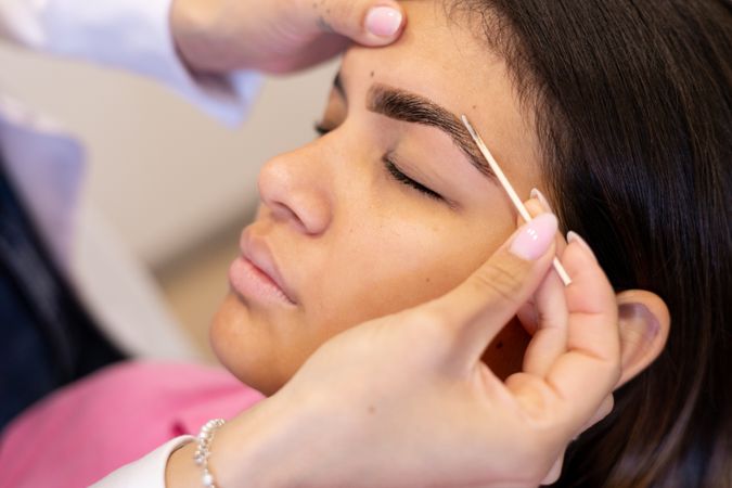 Beautician making eyebrow design and shading procedures