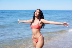 A Joyful Woman at the Beautiful Beach Embracing the Refreshing Ocean Breeze with Delight