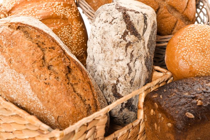 Bakery products in straw basket as background, closeup